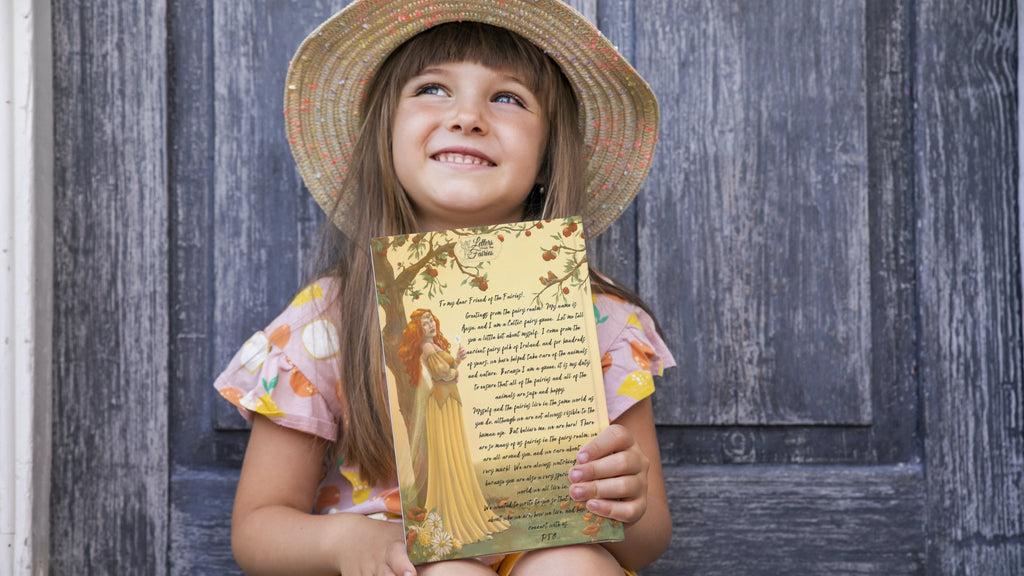 Young smiling girl holding a fairy letter